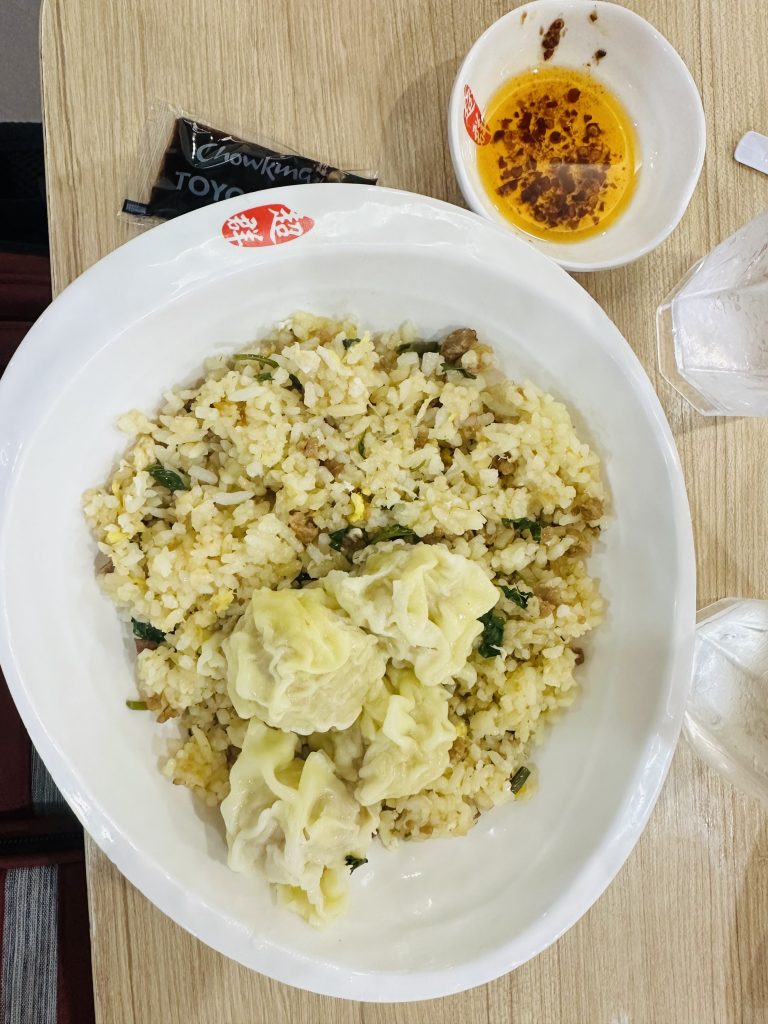 A bowl full of fried rice and dumplings in it.