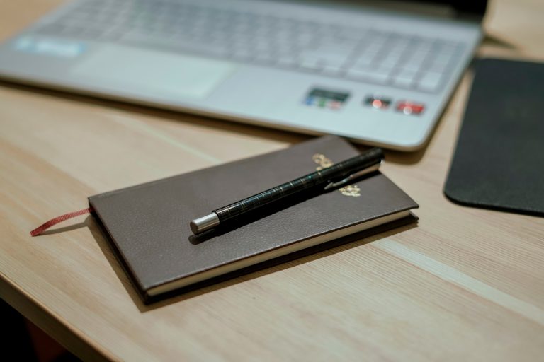 Black color book with a Premium ball pen placed on a wooden table #book #ballpen