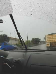 Vista dentro de vehículo afuera fuerte lluvia, vidrio mojado. 