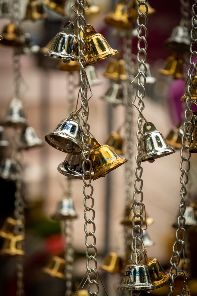 Small gold an silver-colored bells at a temple in Thailand