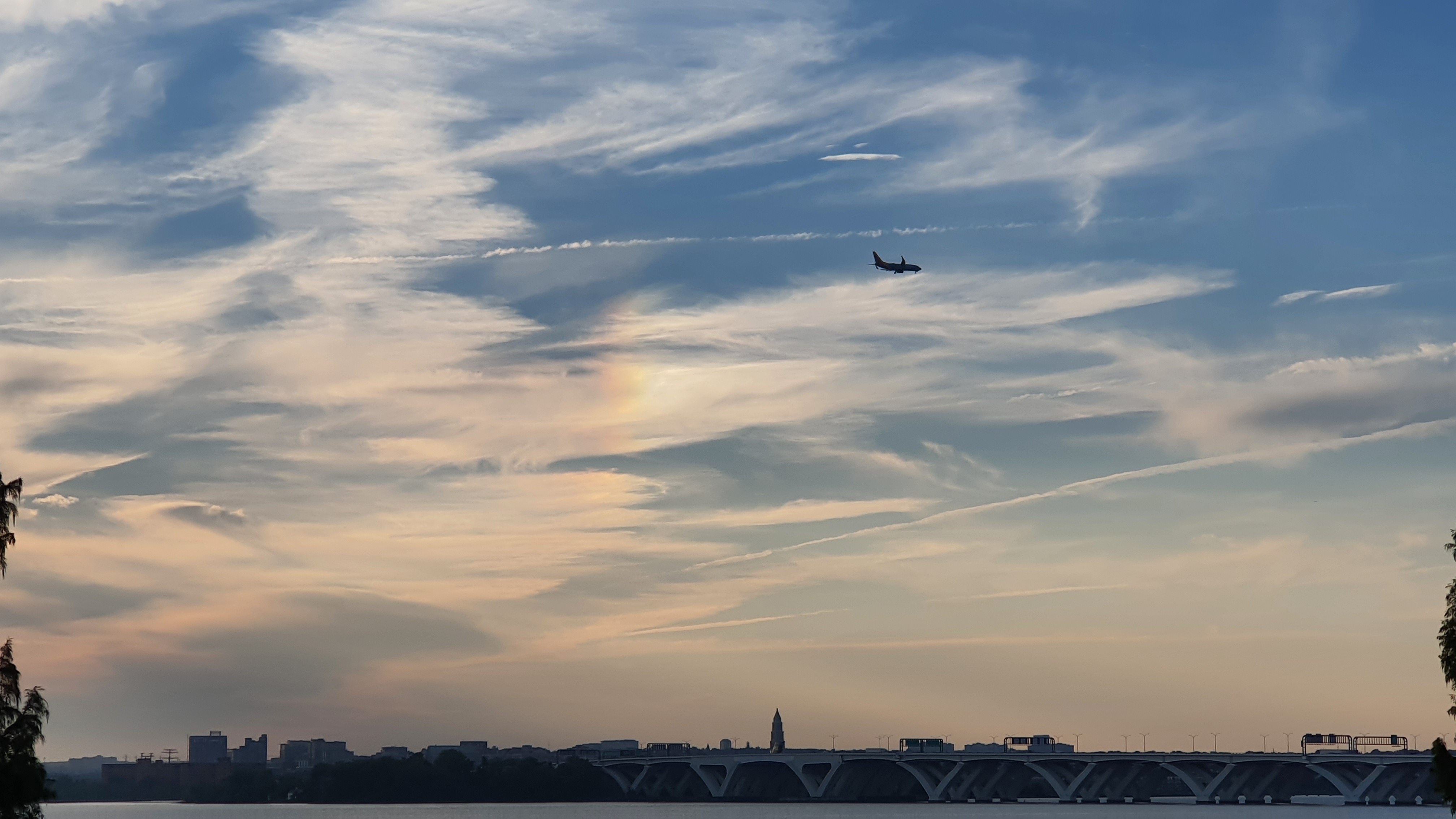 Flight final approach over the Woodrow Wilson Memorial Bridge, Maryland, USA. Dusk sky with slightly iridescent cloud