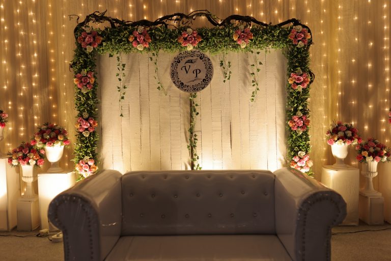 A decorated wedding stage with a sofa.