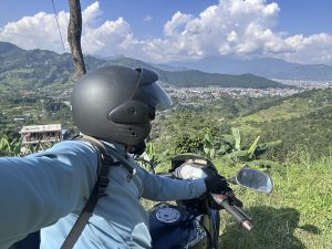 Man riding on a motorbike and pokhara city in the background! 