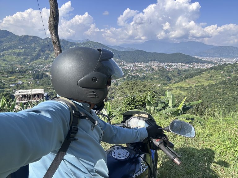 Man riding on a motorbike and pokhara city in the background!