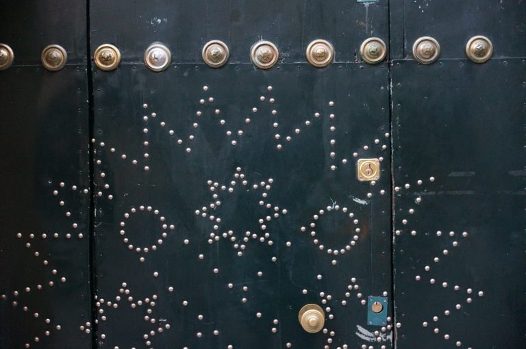 Green church door with brass ornaments