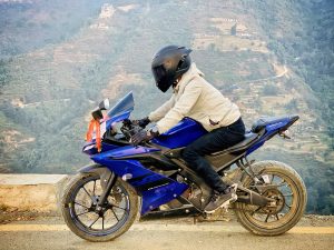 A man with a black helmet on, cruising on a motorcycle.