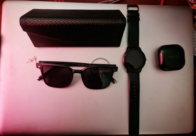 Showcasing sunglass, a smartwatch, and earbuds.