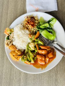 A plate full of rice, tofu, chicken, noodles and salad. 