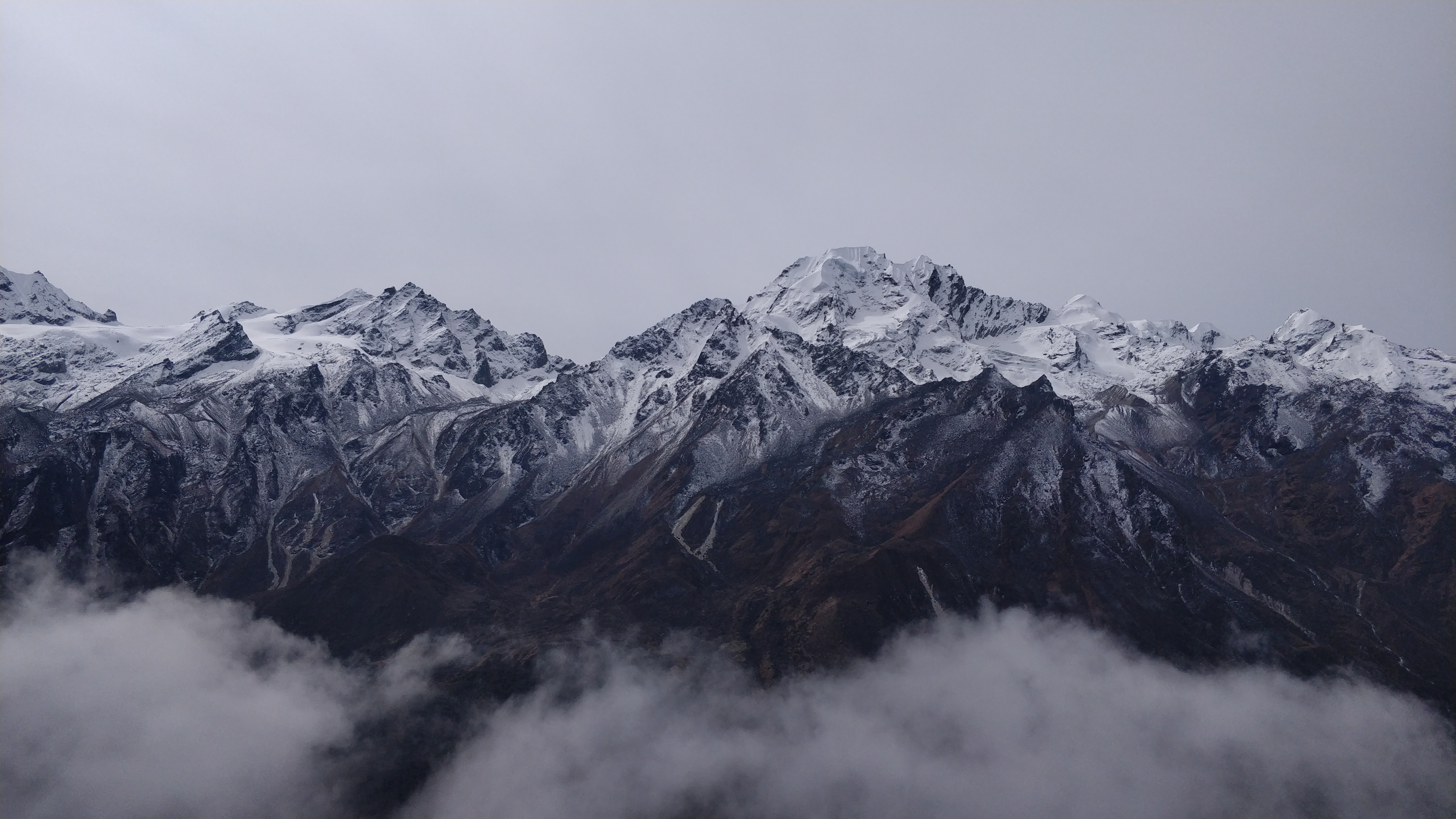 Langtang Trek, standing above the clouds looking at the mountains with a snowy summit