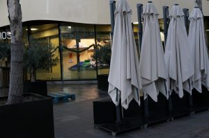 Row of closed umbrellas at a cafe's terrace