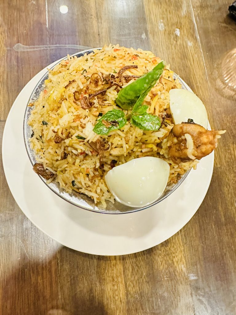 A decorated bowl of Chicken biryani. It’s a mixture of rice, chicken, ghee and other ingredients. It is popular in Nepal, India and Bangladesh.