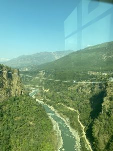 A wire bridge over the tree-filled Kaligandaki River valley with a bungee jump on it.