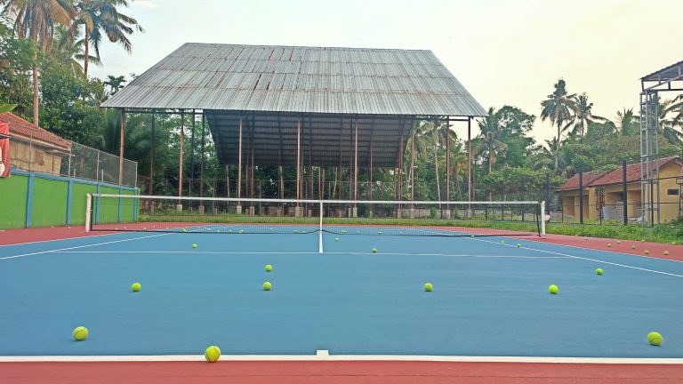 A tennis court scattered with numerous tennis balls.