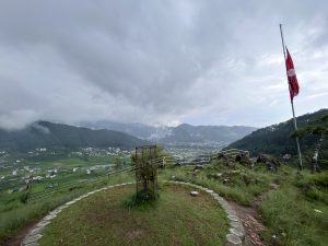 The flag of Nepal and the scenic vista of Godawari.