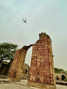 Past and the present. A flight is flying on the top of ruins in the Qutb Complex, New Delhi. 