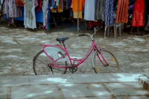 A pink bicycle parked in a park