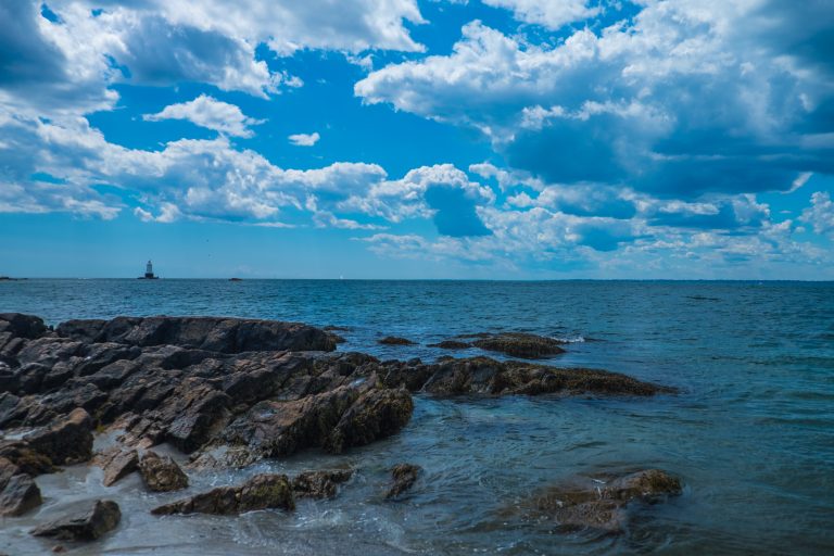 The Sakonnet Lighthouse peers out across the bay at Newport, Rhode Island in the distance.