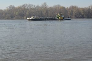 A small commercial boat cruising down a river