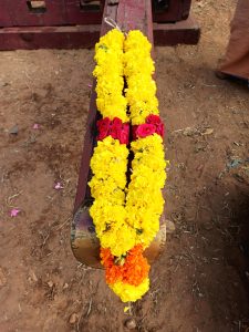 View larger photo: A garland made of yellow-orange marigold ( Jamanthi ) flowers and red roses.