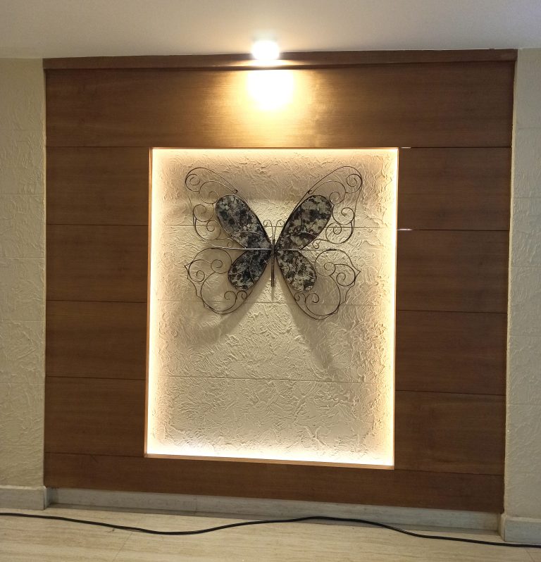 A framed metal butterfly decoration on a wall.