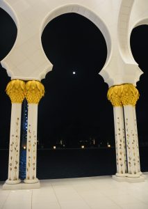 Moon between two pillars. A night view from Grand Mosque, Abu Dhabi, United Arab Emirates. 