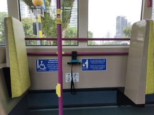 A public transit bus interior with a handicap accessible seat.