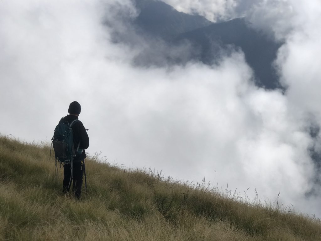 Trekker in Himalayas watching view of clouds