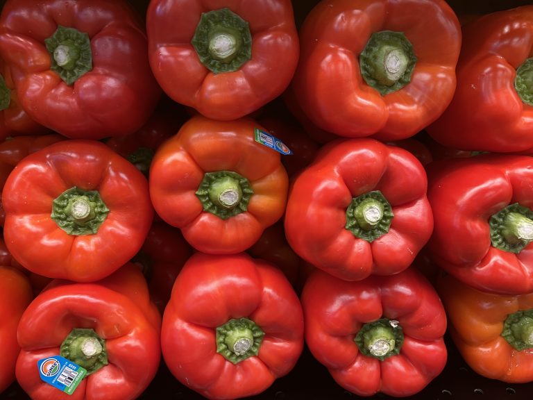 Red peppers, all packed stem side toward the viewer.