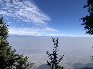 A beautiful view of Kathmandu Valley from the top of the hills. A stunning mountain range at the end and some clouds in the sky. 