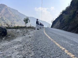 A black and white pole standing on the roadside for safety purposes