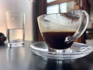 Coffee in the foreground, with a background of a glass of water!