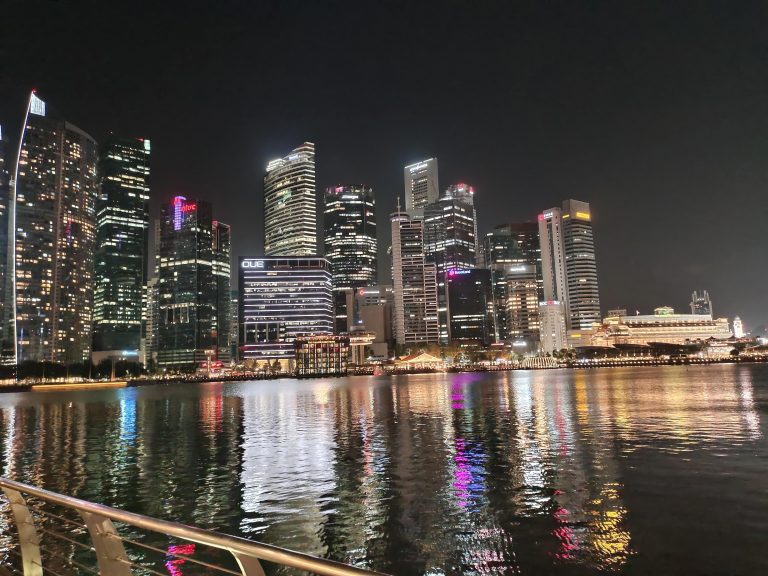 City skyline at night, lights reflecting on water. A mesmerizing urban landscape illuminated by vibrant lights.