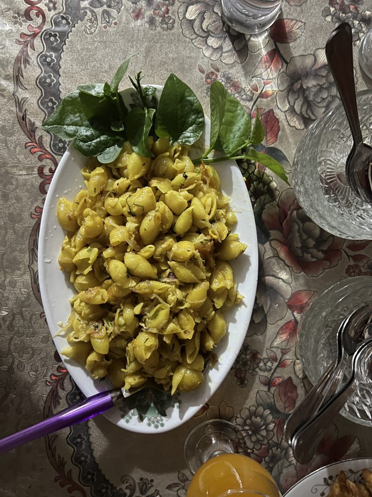 A plate of Pasta and some number of spoons in a table.