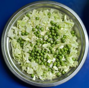 A bowl of green peas and cabbage