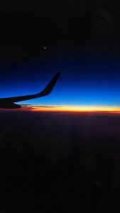 Sunset view from a flight with its wings and moon in the frame. 