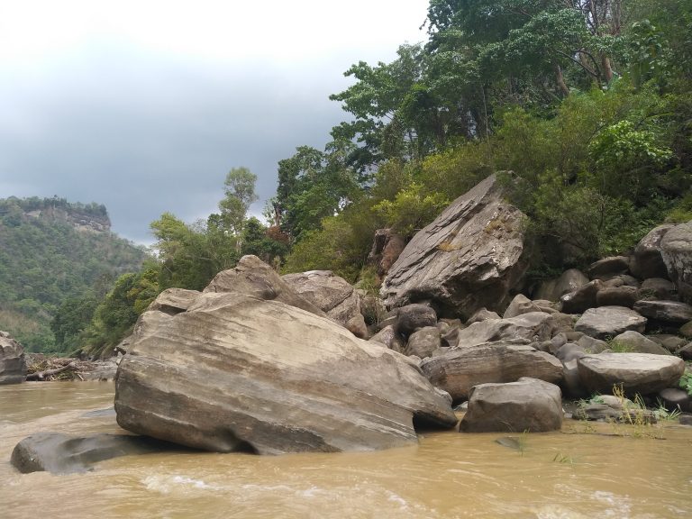 A serene river flowing over rocks, creating a beautiful scene of nature’s tranquility.