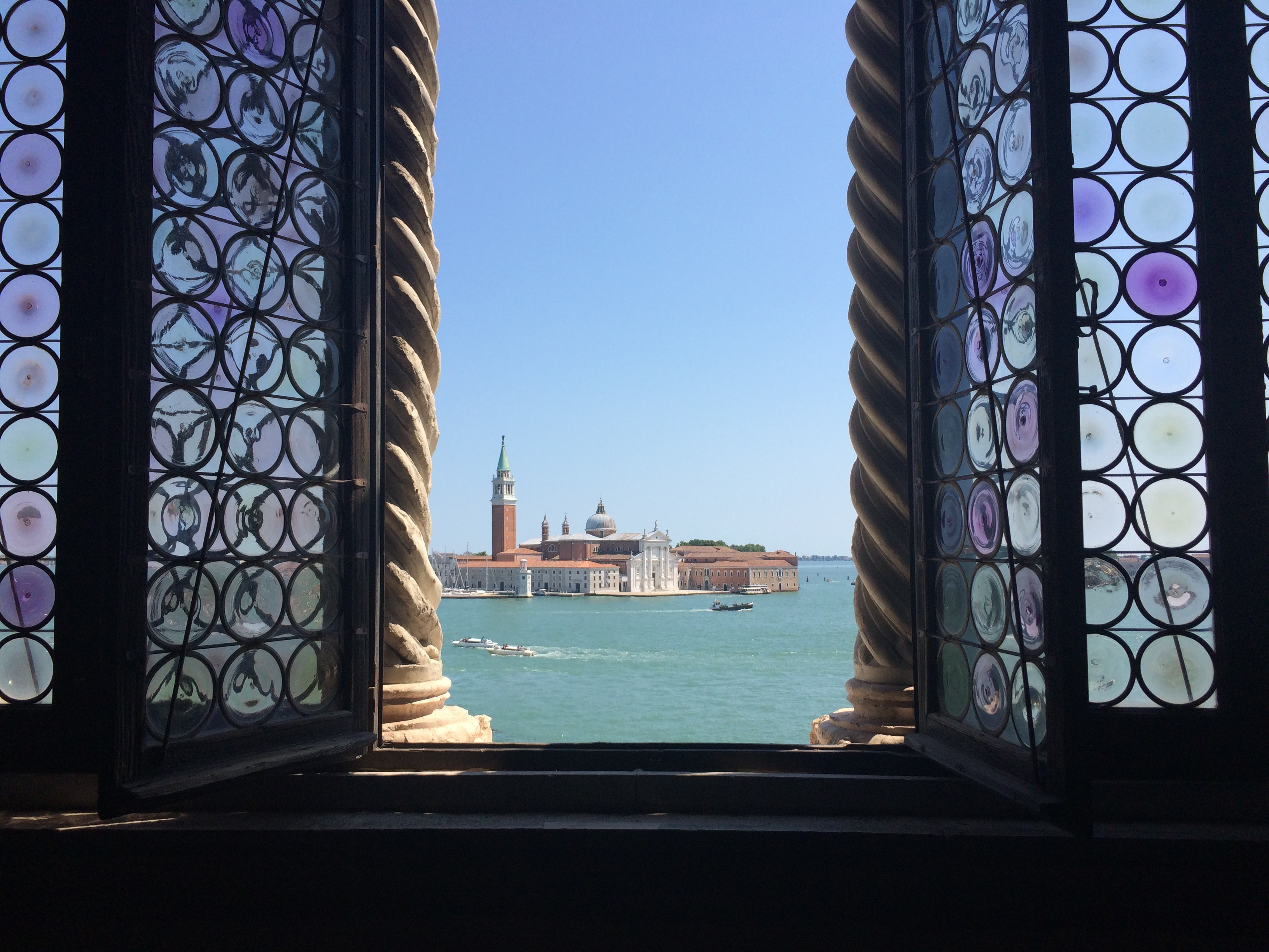 Church of San Giorgio Maggiore viewed through stained glassed windows and columns of the Doge's Palace