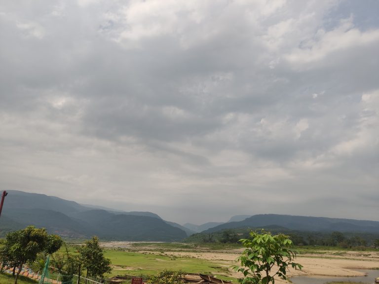 A landscape with trees, rivers, sky, and mountains.