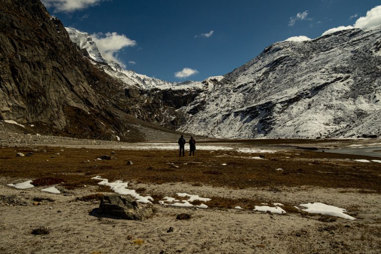 Two individuals delighting in the charming view of the Himalayan landscape.