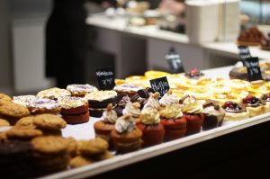 Muffins and other pastries seen through a shop window