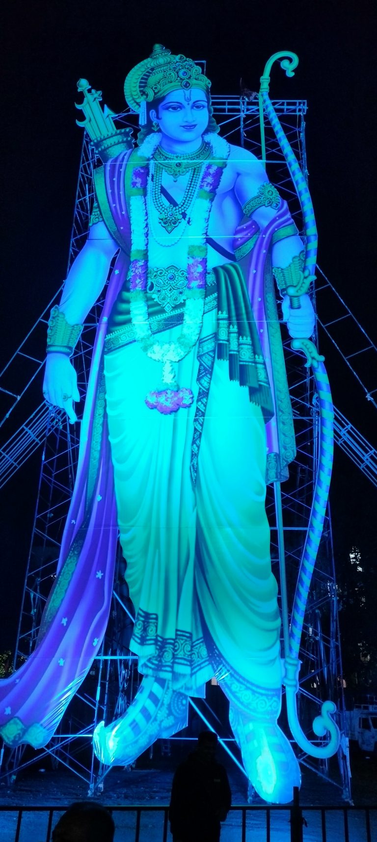 A 60 feet tall photo of hindu god ram illuminated during night.