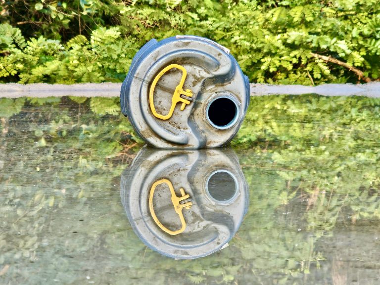 An empty chemical bottle & its reflections on the water to wet the concrete. From our neighbourhood, Perumanna, Kozhikode, Kerala.