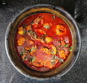 Spicy Kerala-style red chili fish curry in a clay pot.