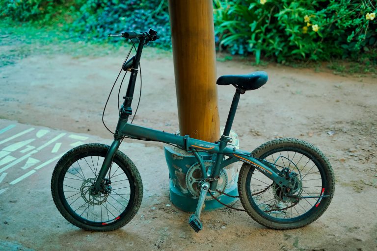 An old bicycle with a loose chain leaned on a fence post