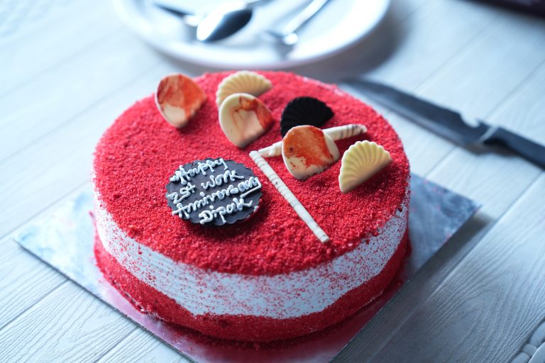 Anniversary cake, red sugar on top and bottom so it looks like a big cookie. Small shell decorations on top, and a tiny anniversary note in chocolate.