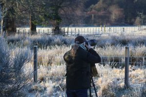 Photographer at work outside on cold frosty morning in Scotland