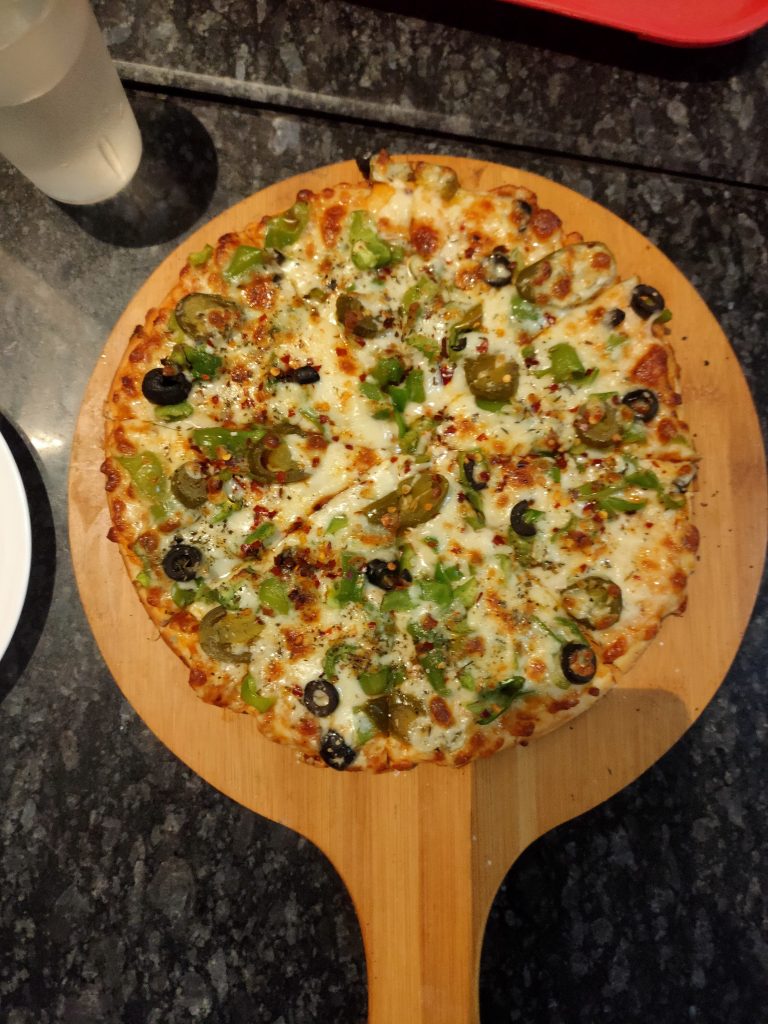 A delicious Pizza served over a wooden plate