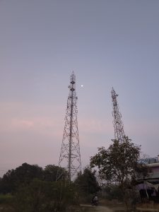 Two internet network towers in a field and an evening sunlight