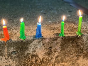 Colorful candles burning and dripping down from Noche de las Velitas (Night of the Little Candles) – a Colombian holiday in December.
