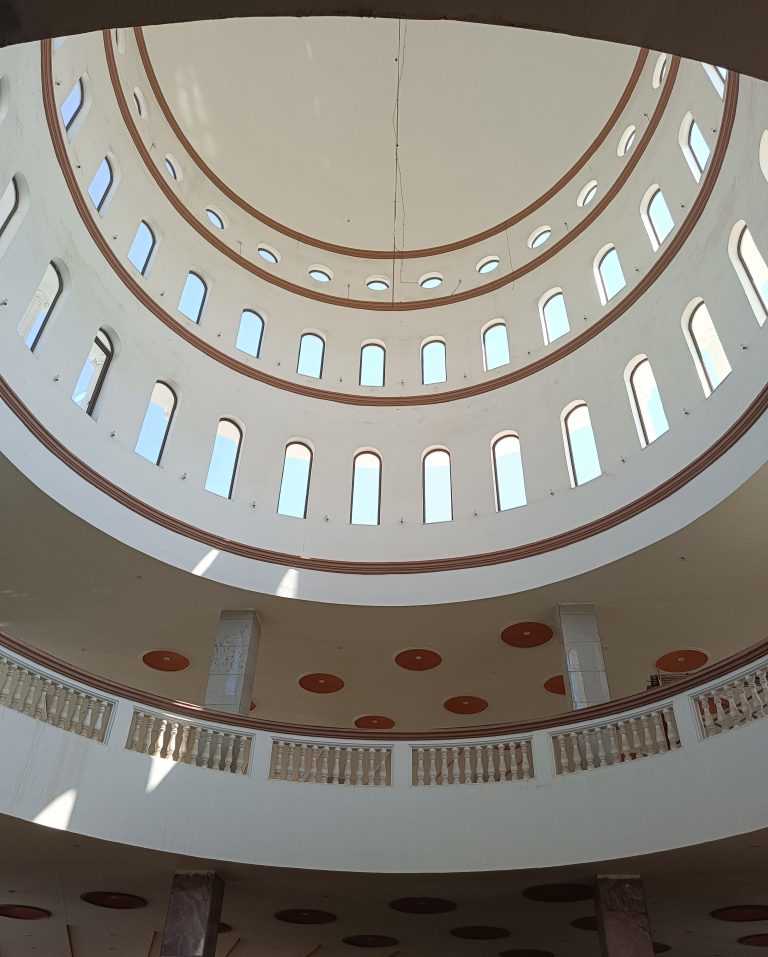 Looking up at a domed ceiling with balcony and windows